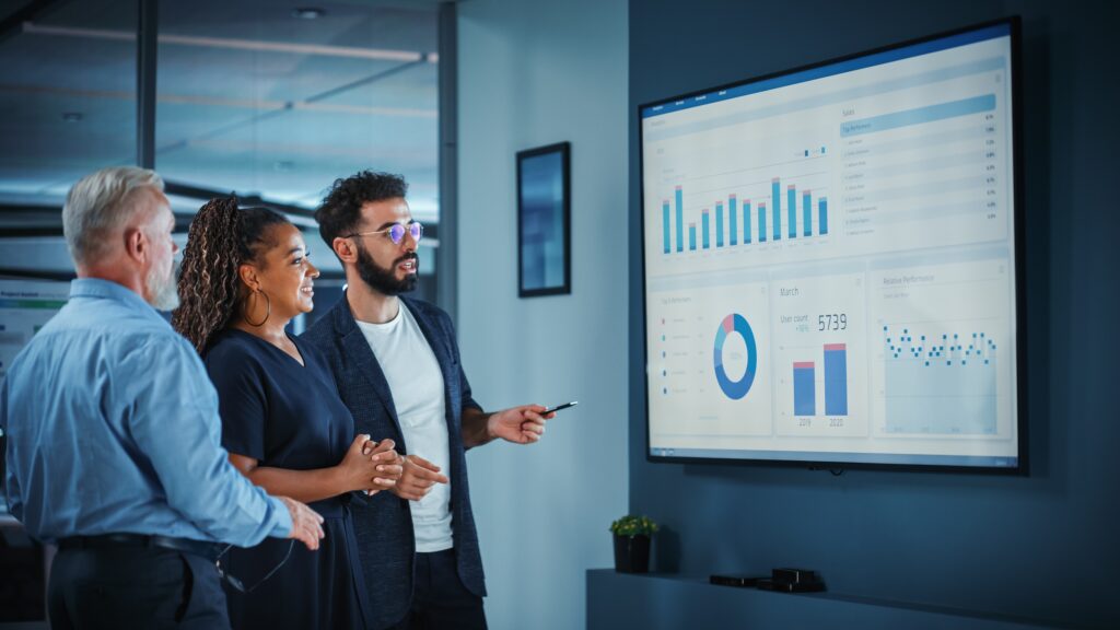 Decorative image. A team of professionals analyse data using AI tools in HR