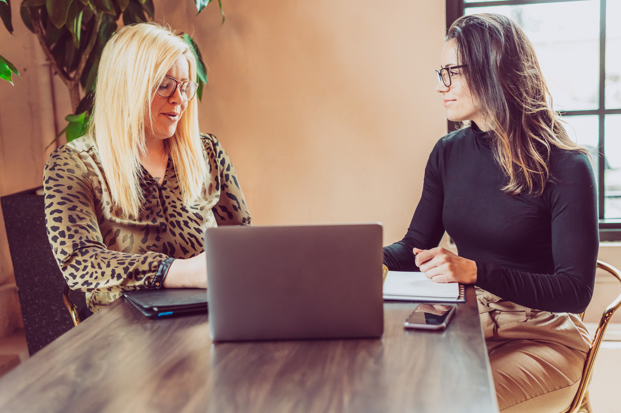 Decorative. Two HR professionals discuss the benefits of AI in HR.